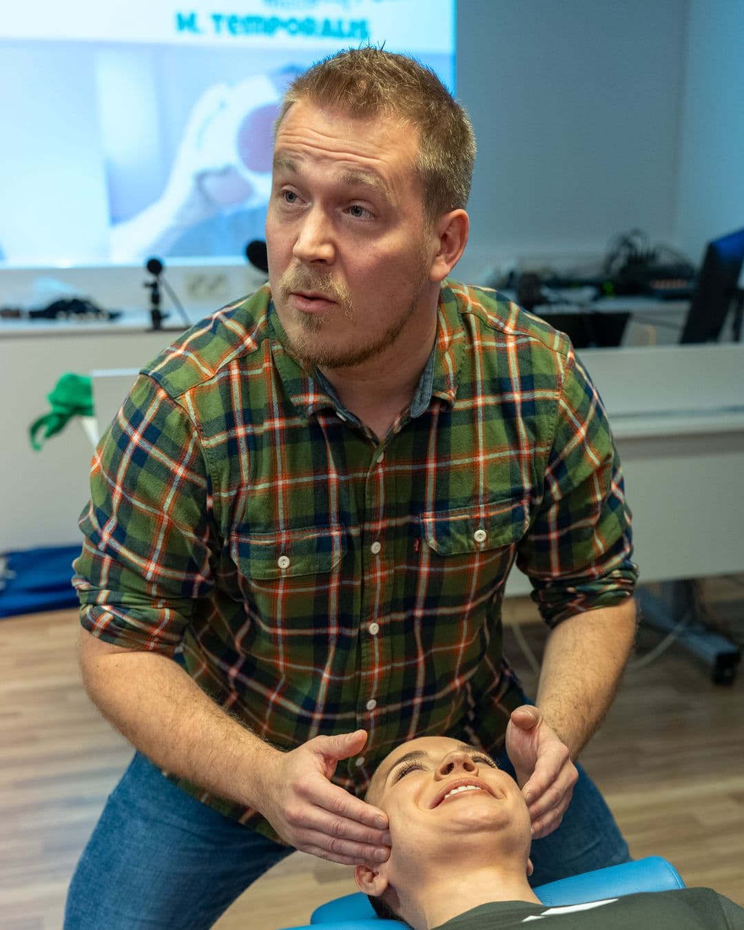 Janne Säkkinen tunnustelee leukaniveltä koulutuspäivässä